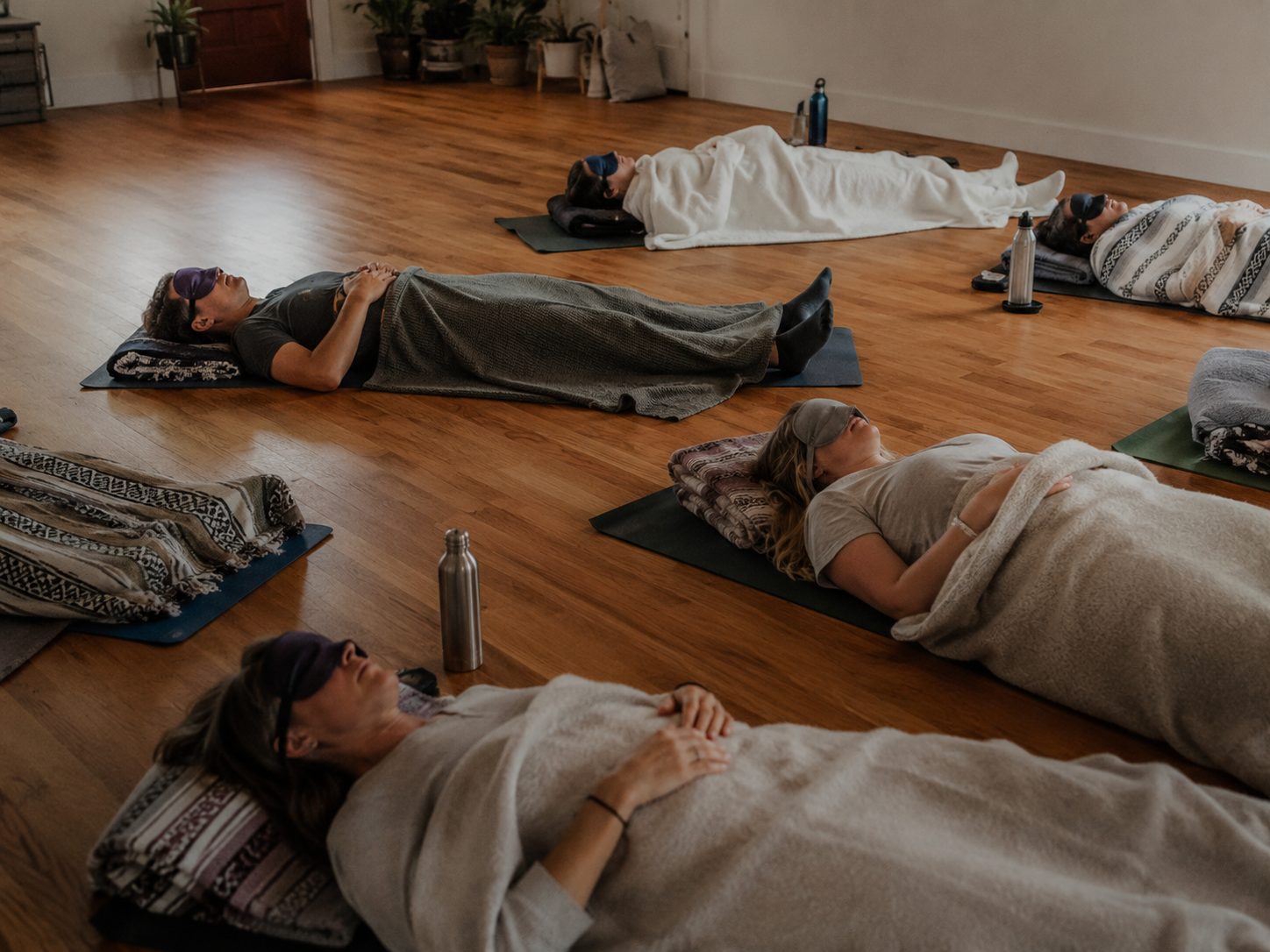 A held session — participants resting under blankets during a Self-Exploration Retreat