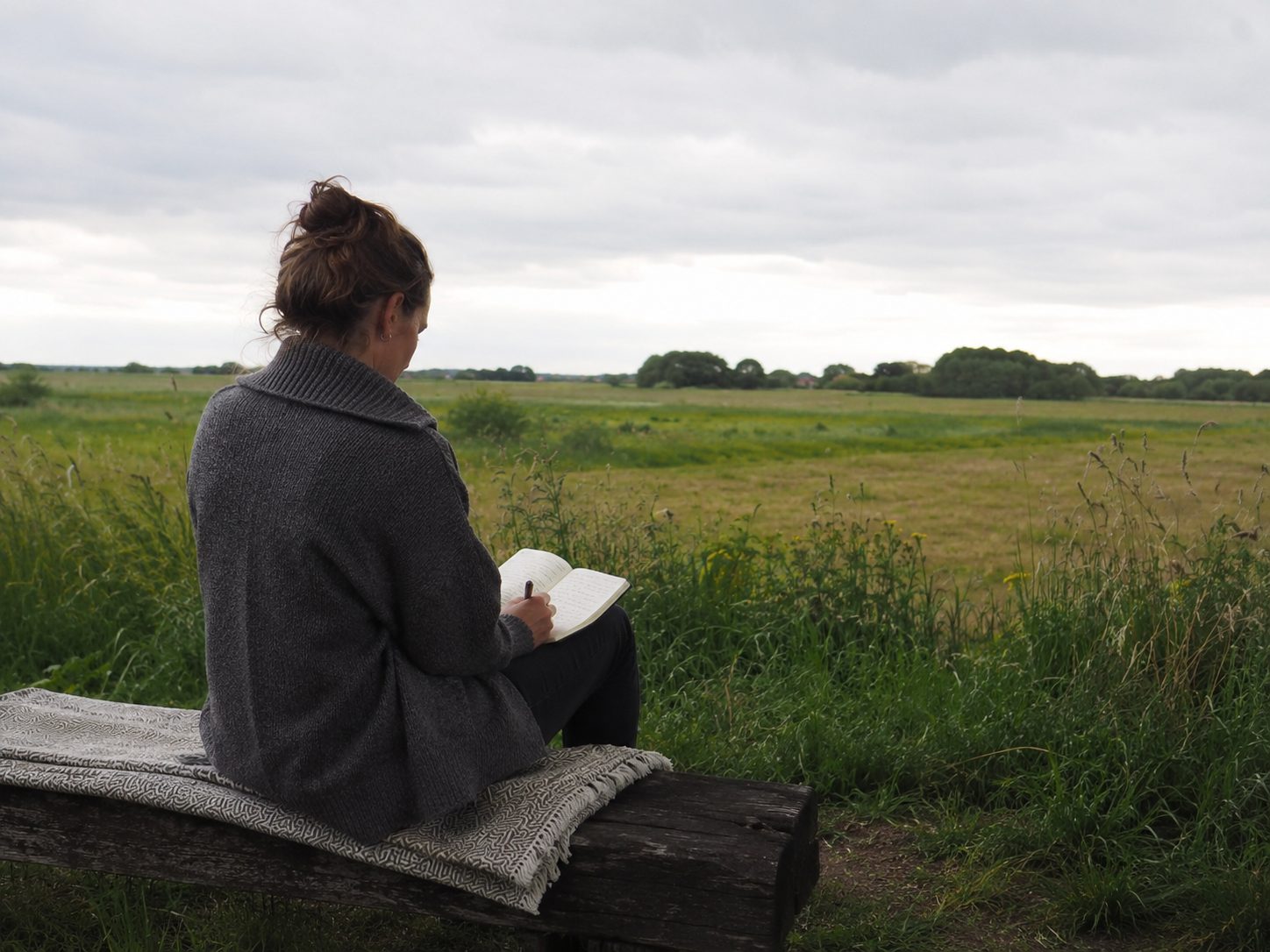 Person alone in a field in quiet reflection