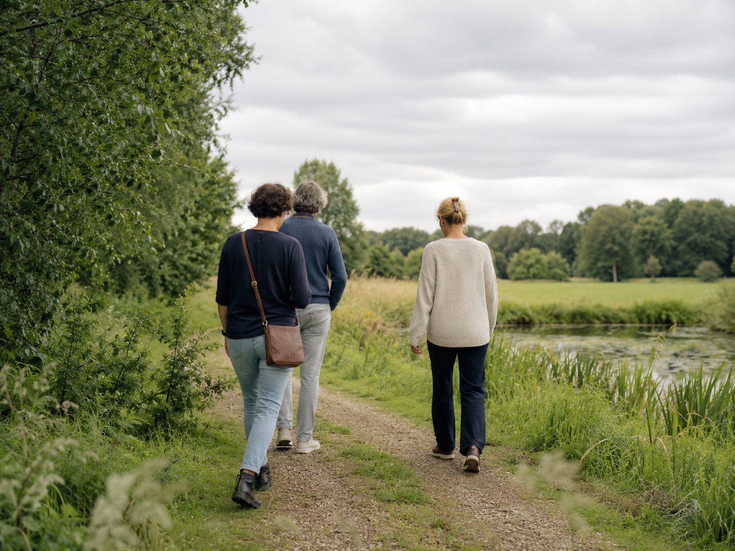 Two people walking by the water